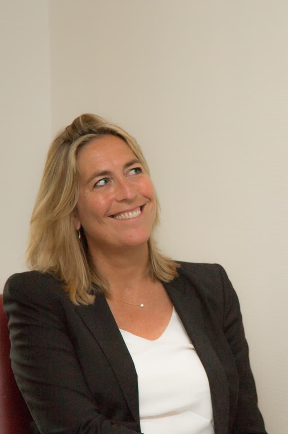 Executive coach Dymphe Beek, seated against a light wall